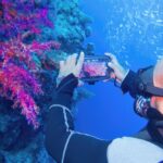 Man,Scuba,Diver,Using,Smartphone,Underwater,Housing,When,Shooting,Coral